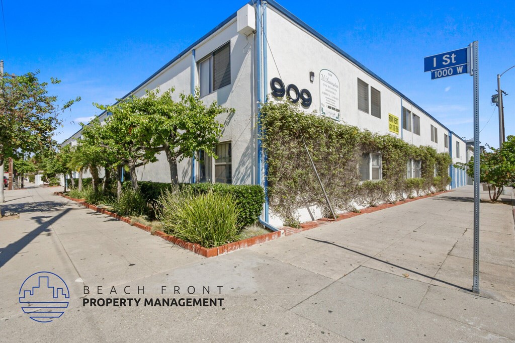 A building with the number 900 on it is shown with a sign that says 1st St 1000 W.