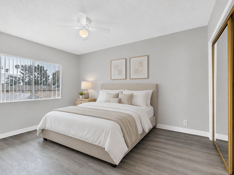 A bedroom with a large bed and a ceiling fan.