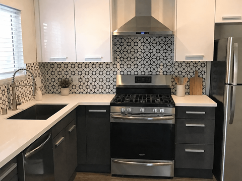 A modern kitchen with black and white tiles.