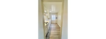 A kitchen with white cabinets and a window.