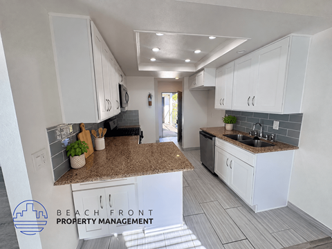 A kitchen with white cabinets and a granite countertop.
