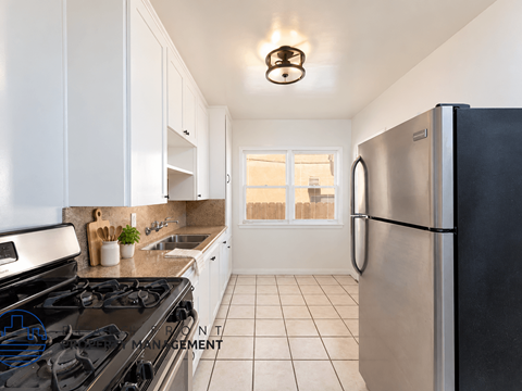 A kitchen with a black stove top oven and a black refrigerator.