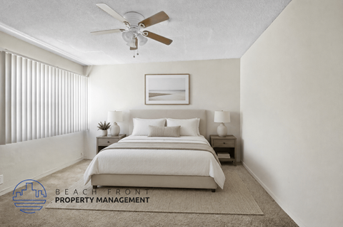 A bedroom with a bed, nightstands, and a ceiling fan.