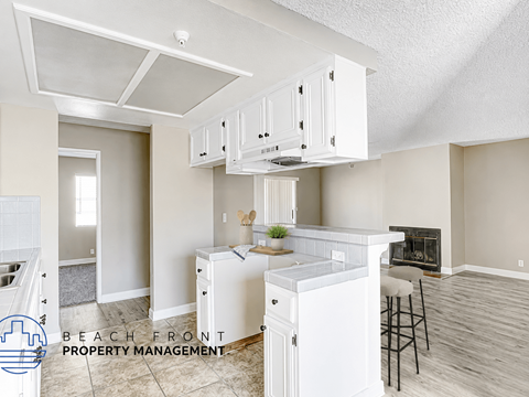 A kitchen with white cabinets and a stove top oven.
