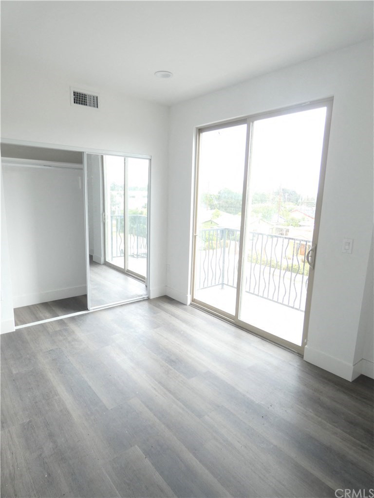 an empty living room with wood flooring and sliding glass doors