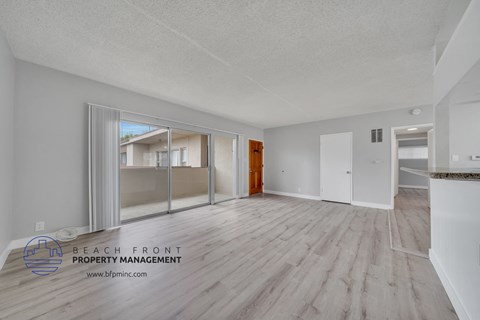 the spacious living room with wood flooring and sliding glass doors