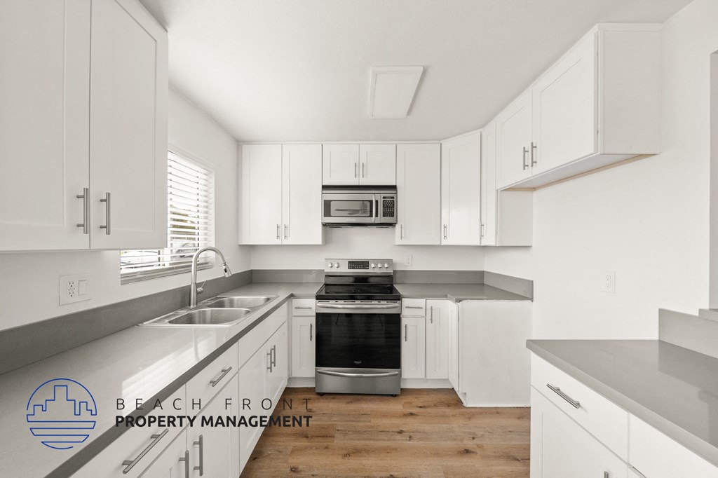 A kitchen with white cabinets and a stainless steel oven.