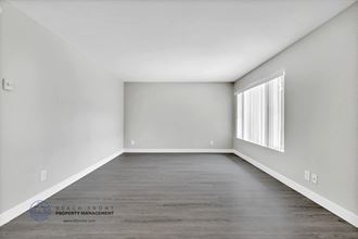 an empty room with gray walls and a large window