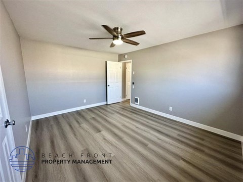 a living room with wood flooring and a ceiling fan