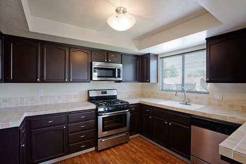 a kitchen with a stove and a sink and a microwave