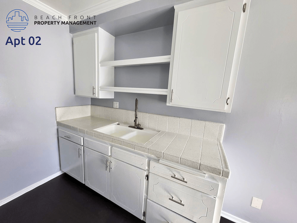 a white kitchen with white cabinets and a white sink