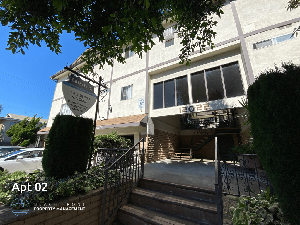the front of a building with stairs and a sign