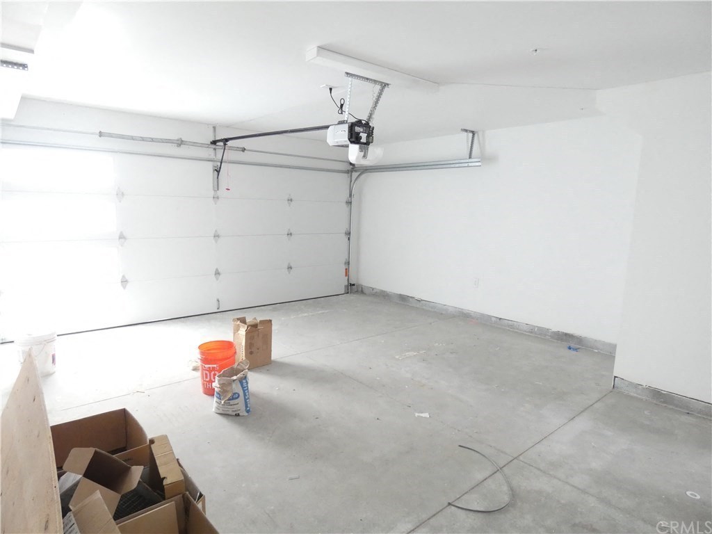 a garage with a white wall and boxes on the floor