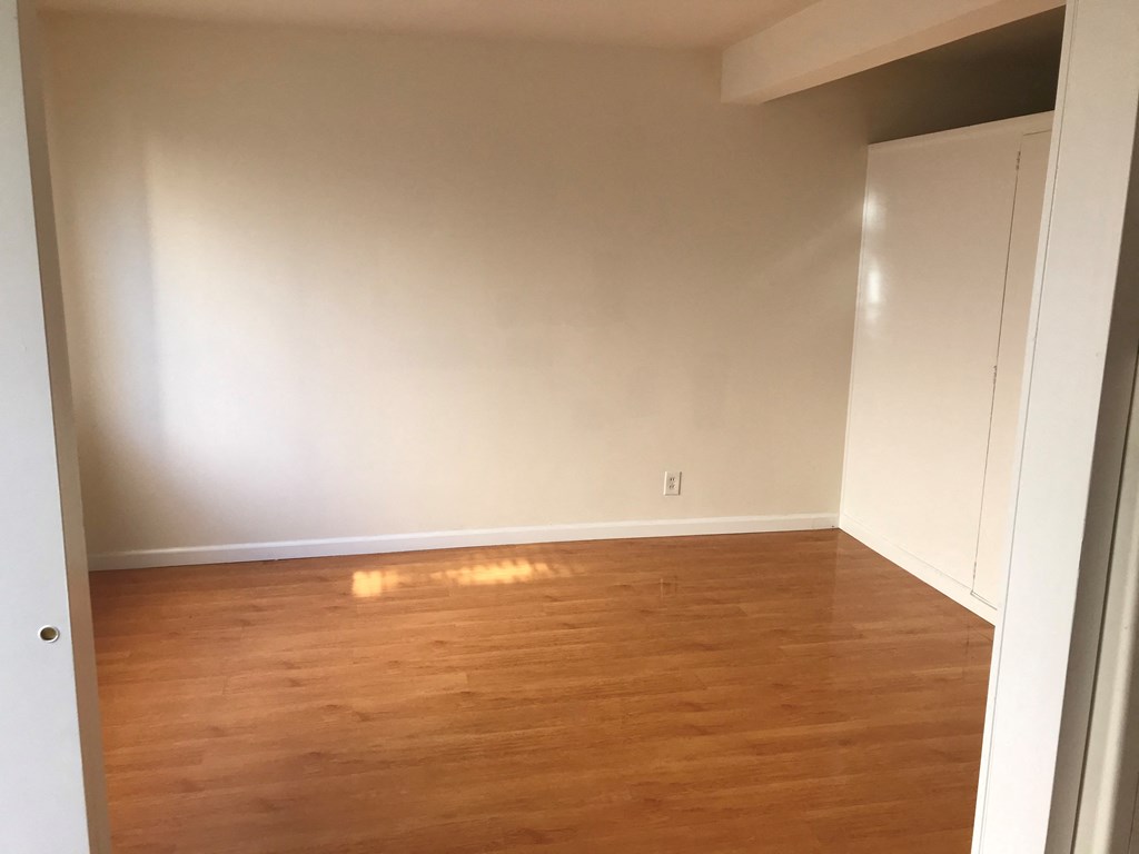 an empty room with wooden floors and white walls