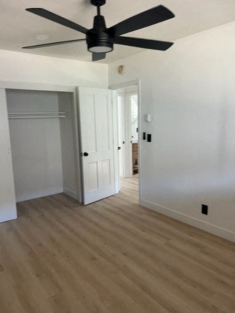 a empty room with a ceiling fan and a door
