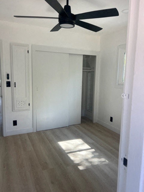 a white room with a ceiling fan and a closet
