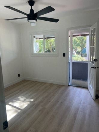 a empty room with a ceiling fan and a door