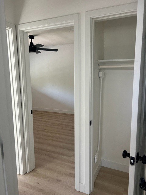a hallway with a closet and a ceiling fan