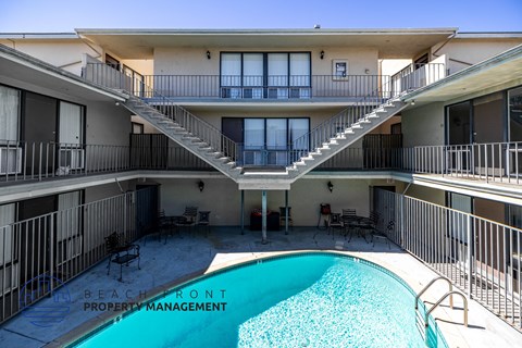 A pool in a courtyard surrounded by apartment buildings.