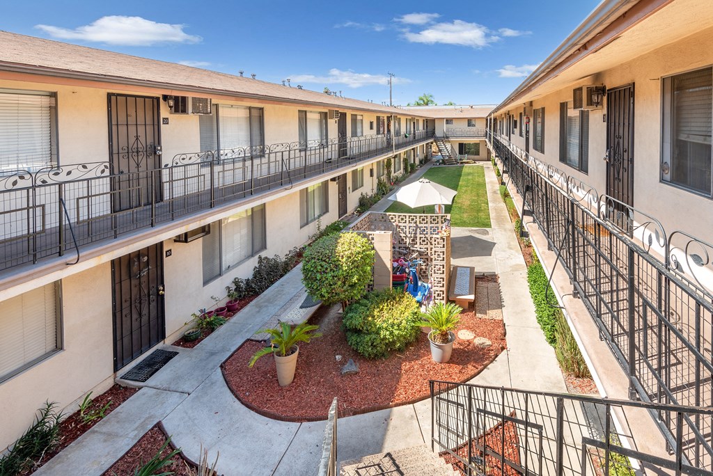 a courtyard with plants and tables in the middle of a building
