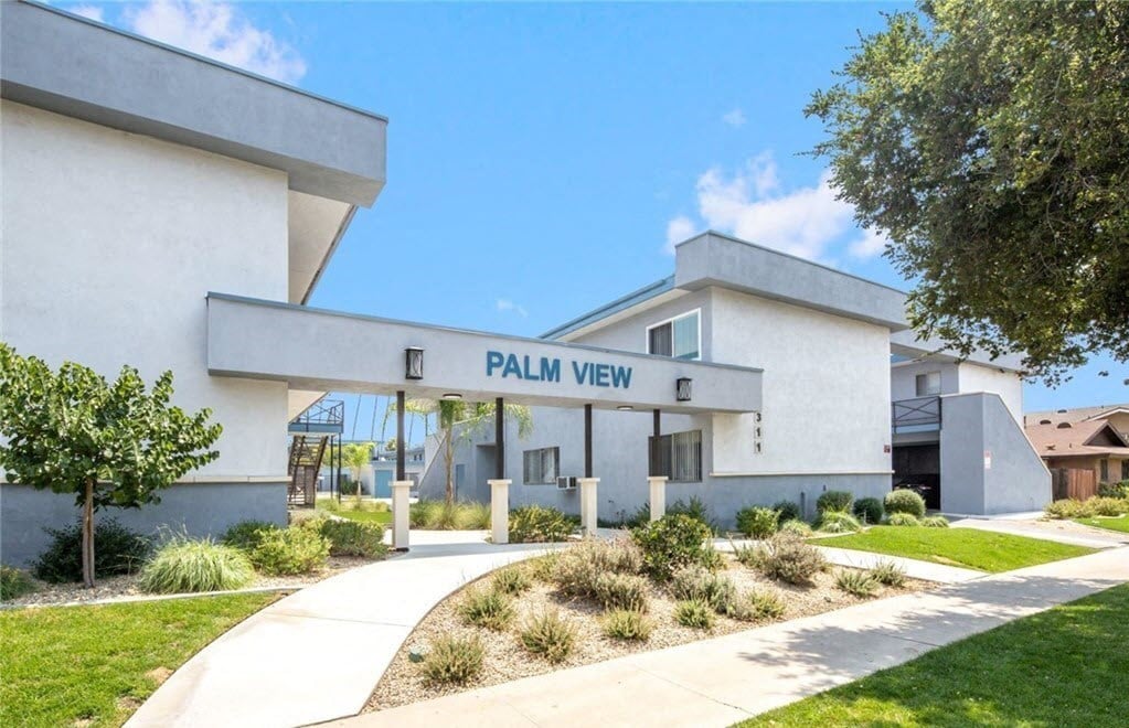 a white building with a sign that reads palm view