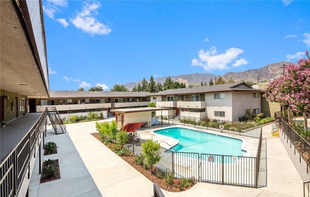 a view of a pool and a building with mountains in the background
