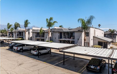 A parking lot with cars and a building in the background.