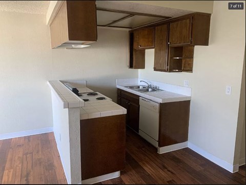 A kitchen with a white stove top oven and a white dishwasher.