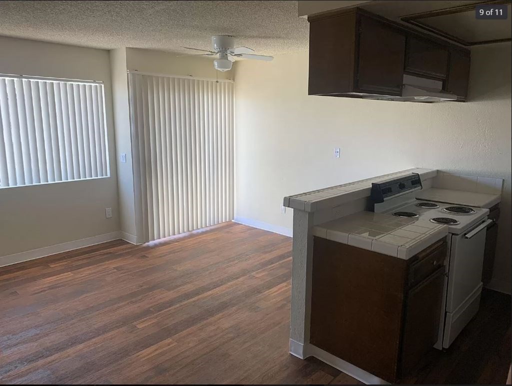 A kitchen with a white stove top oven and a white microwave above the counter.