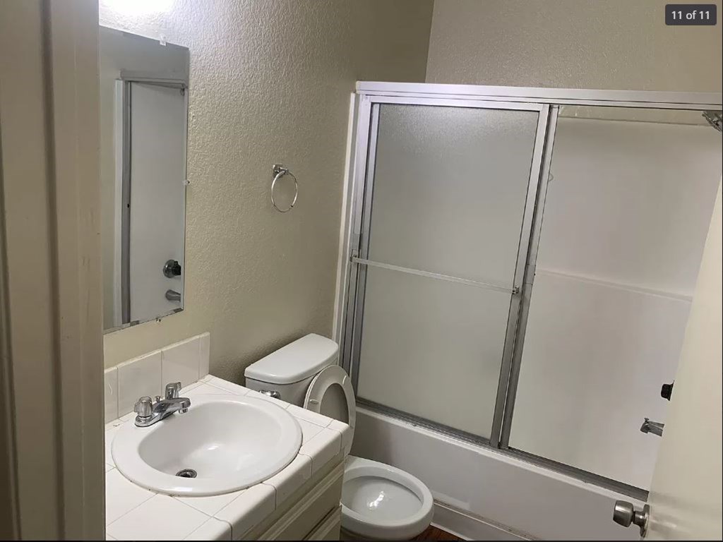 A bathroom with a sink, toilet, and shower.