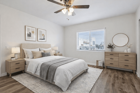 A bedroom with a bed, dresser, and window.