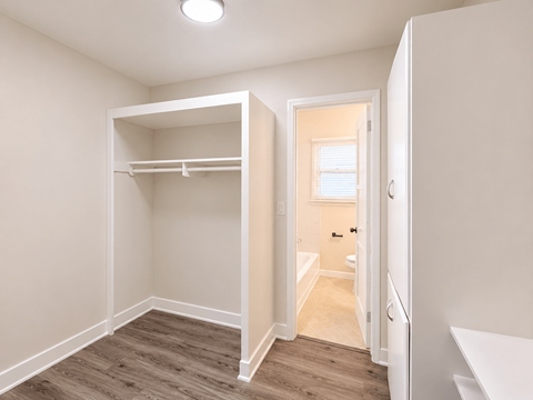 A small bedroom with a bunk bed and a doorway leading to another room.