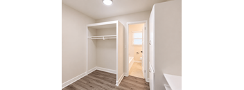 A small bedroom with a bunk bed and a doorway leading to another room.