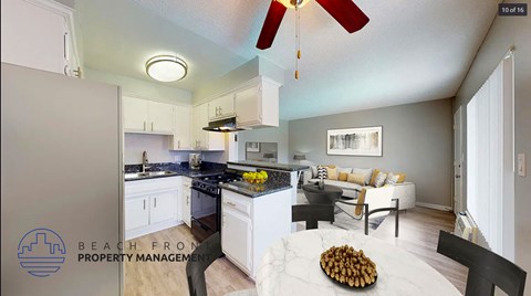 A kitchen with a fan and a dining table with chairs.