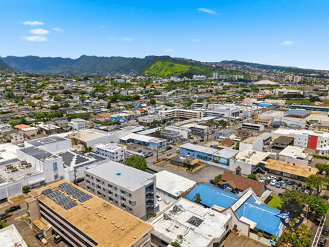 A cityscape with buildings and solar panels on the roofs.