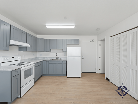 A kitchen with a white stove top oven and a white refrigerator.