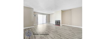 A spacious room with a fireplace and a logo for Beach Front Property Management.
