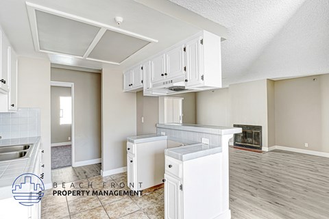 A kitchen with white cabinets and a refrigerator.