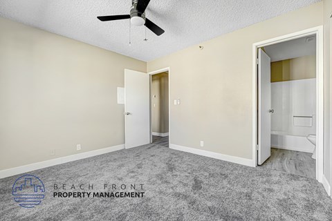 A room with a ceiling fan and a carpeted floor.