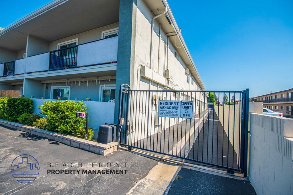 an apartment building with a gated entrance and a white gate