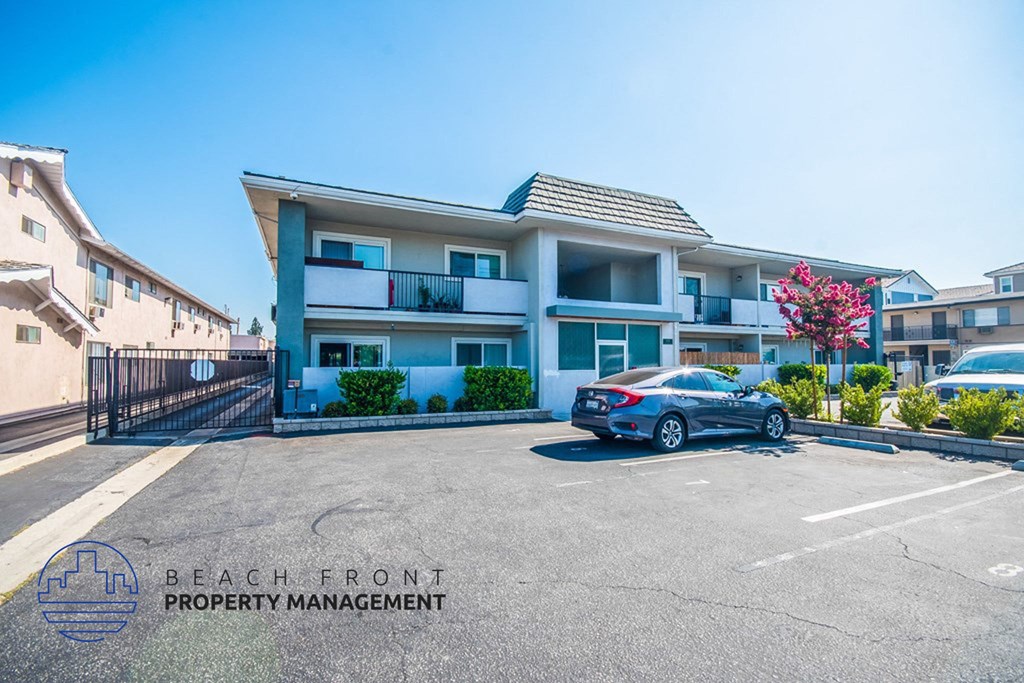 a car parked in a parking lot in front of an apartment building
