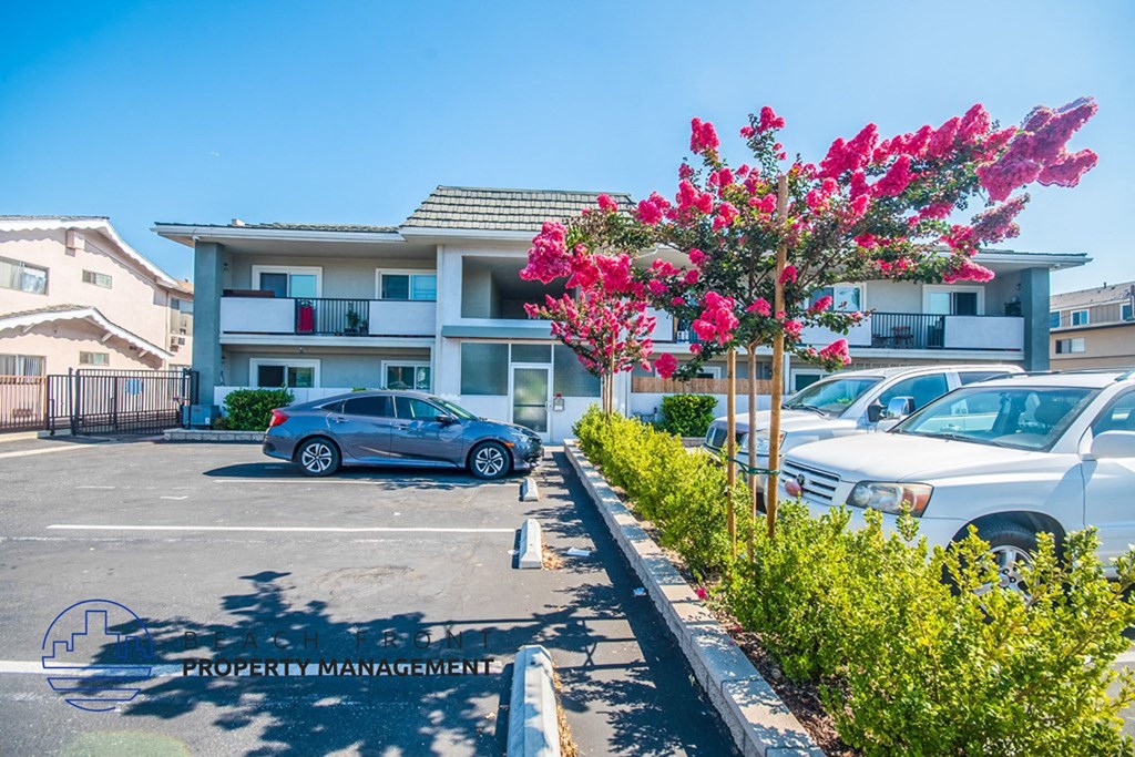 a parking lot with cars in front of an apartment building
