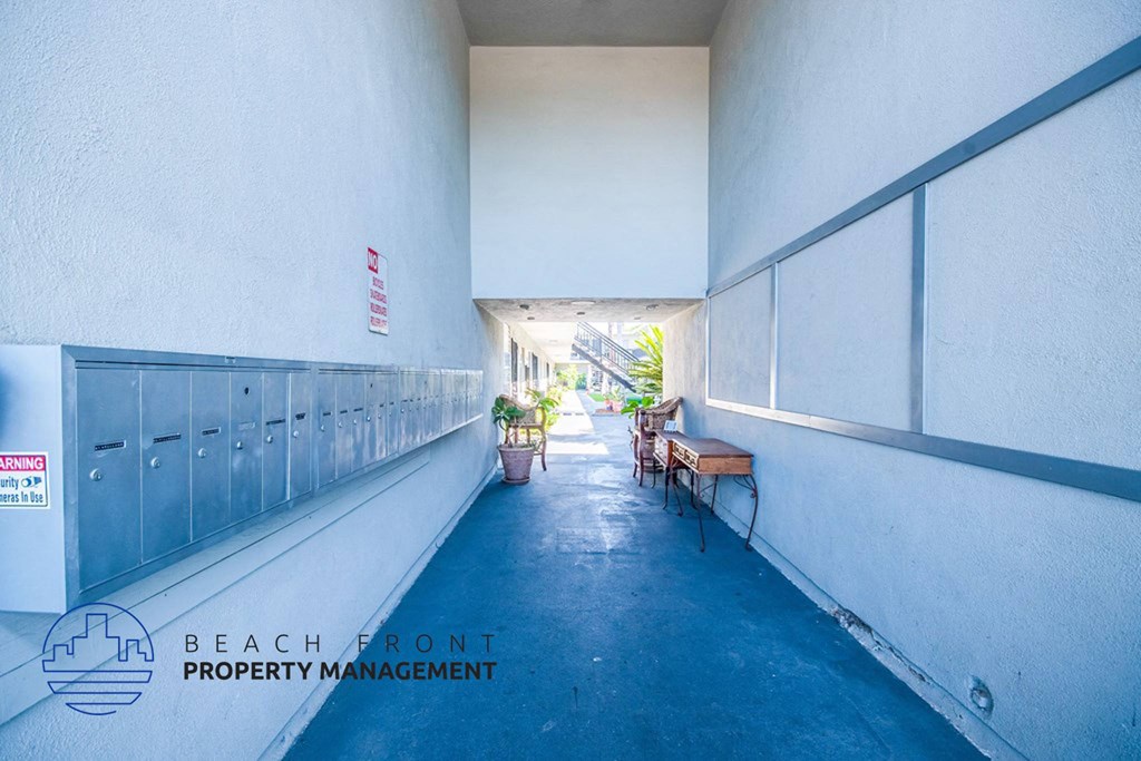 a long corridor with benches and lockers on the side of a building