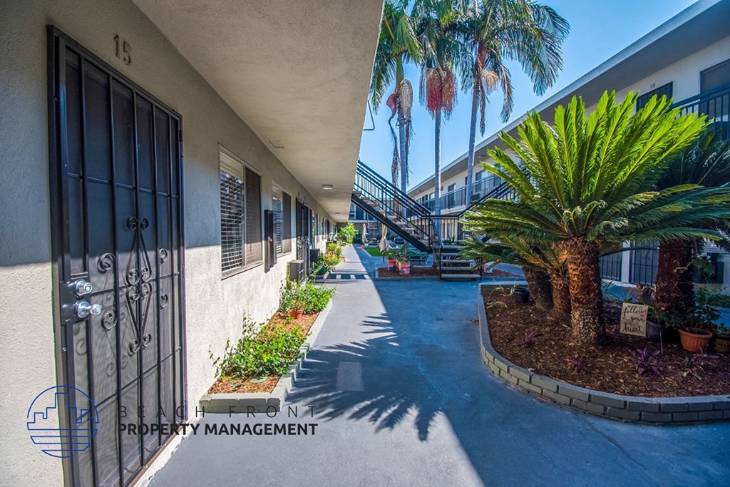 a building with a gate and palm trees in front of it