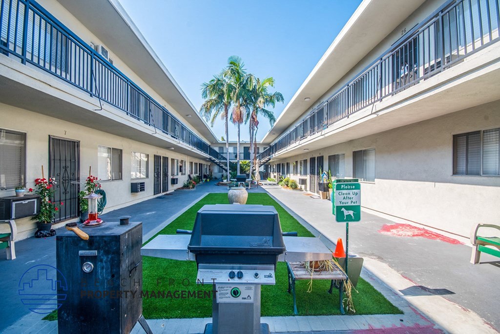 a courtyard between two buildings with a grill in the middle