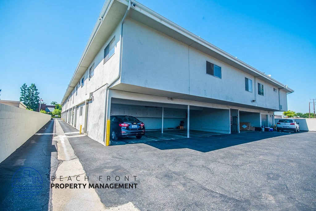 a large white building with cars parked in a parking lot