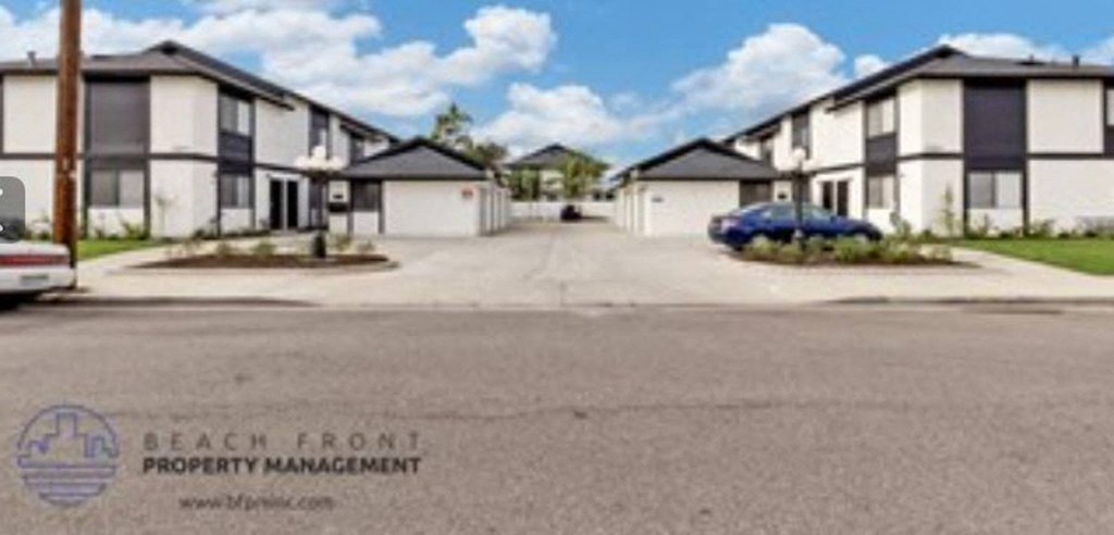 a row of houses on a street with a blue car