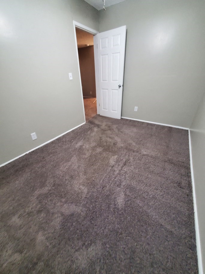 a room with a carpeted floor and a white door