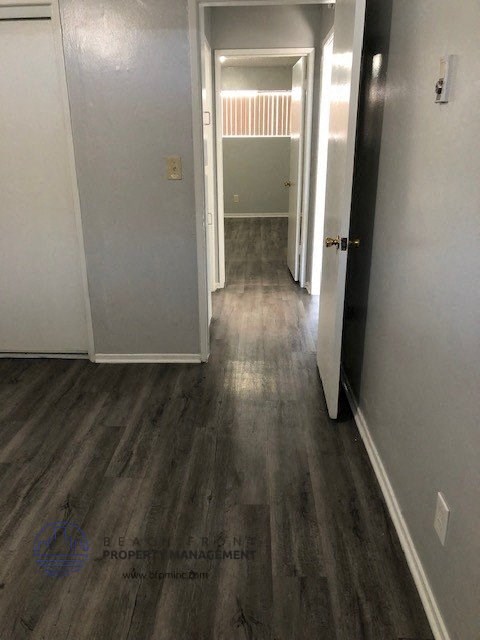 a hallway with wooden floors and white walls