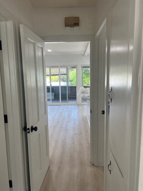 a hallway with white doors and a living room